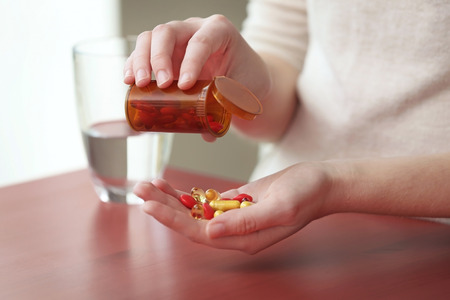 Woman taking vitamins, closeupの写真素材