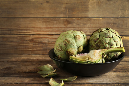 Artichoke on plate on wooden backgroundの写真素材