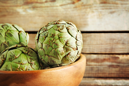 Artichoke in bowl on wooden backgroundの写真素材
