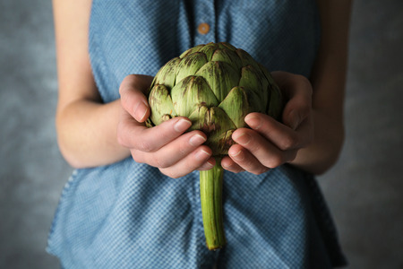 Woman holding artichokeの写真素材