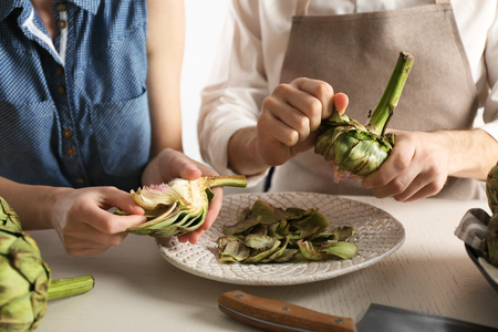 Man and woman cooking artichokesの写真素材
