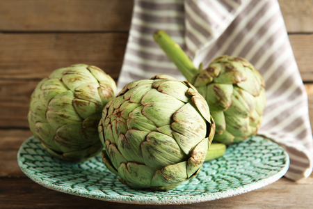 Artichoke on plate on wooden backgroundの写真素材