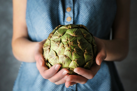 Woman holding artichokeの写真素材