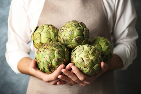 Man holding few artichokesの写真素材
