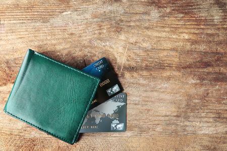 Credit cards in leather wallet on wooden background
