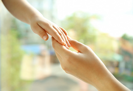 Hands of mother and child on natural backgroundの写真素材