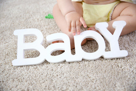 Baby and decorative word on the floorの写真素材