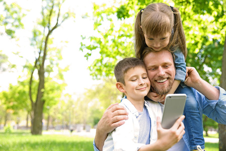 Happy family taking selfie in the parkの写真素材