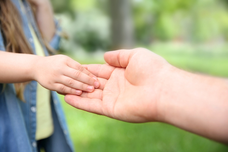 Adult and child hands on natural backgroundの写真素材