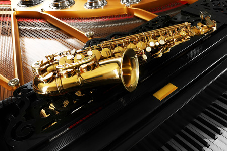 Saxophone lying on the piano, close upの写真素材