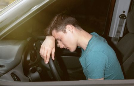 Handsome man falling asleep in carの写真素材