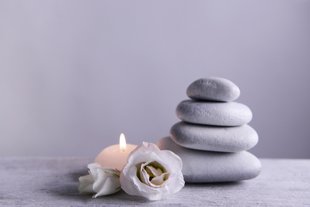 White spa stones with candle on gray backgroundの写真素材