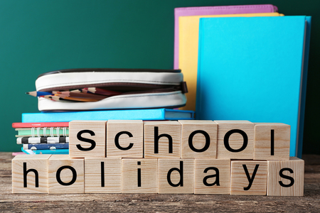 Colourful stationery and words SCHOOL HOLIDAYS on tableの写真素材