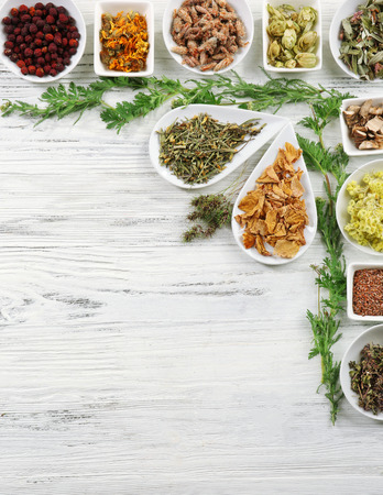 Natural flower and herb selection in ceramic bowls on wooden backgroundの写真素材