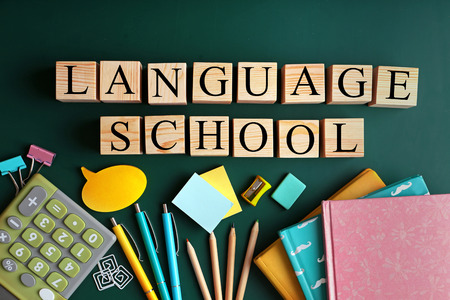 Colourful stationery and words SCHOOL HOLIDAYS on chalkboardの写真素材