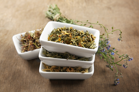 Natural flower and herb selection in ceramic bowls on wooden backgroundの写真素材