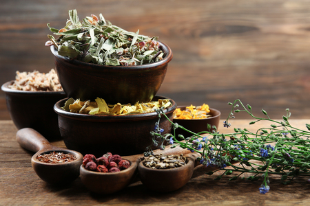 Natural flower and herb selection in  bowls on wooden backgroundの写真素材