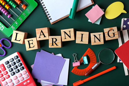 Colourful stationery and word LEARNING on chalkboardの写真素材