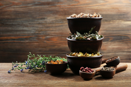 Natural flower and herb selection in  bowls on wooden backgroundの写真素材