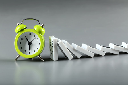 Dominoes and alarm clock on grey backgroundの写真素材