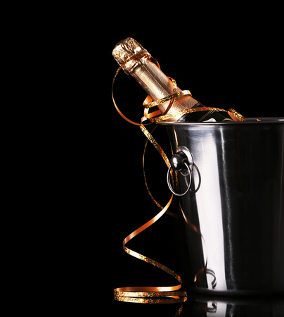 Bottle of champagne with ice in bucket on black backgroundの写真素材