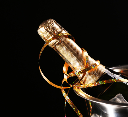 Bottle of champagne with ice in bucket on black backgroundの写真素材