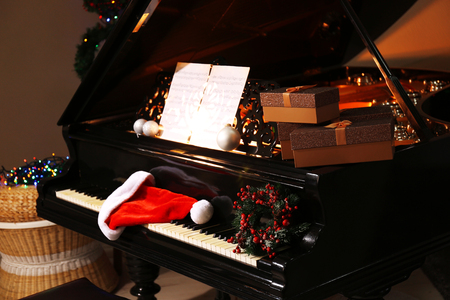 Santa hat and gifts on piano keys with Christmas decorationsの写真素材