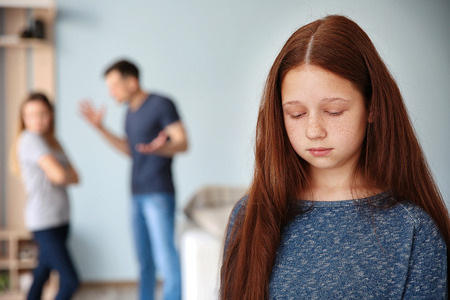 Family problems concept. Sad girl and abusing parentsの写真素材