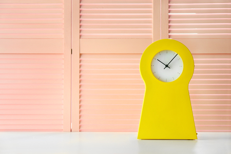Stylish clock on pink folding screen backgroundの写真素材