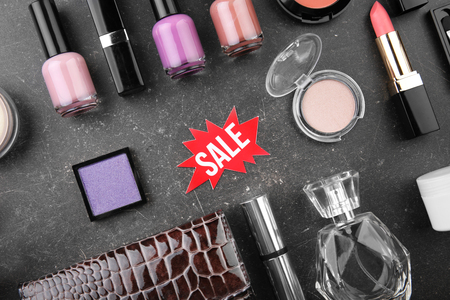 Sale concept. Bright tag with female stuff and cosmetics  on grey backgroundの写真素材
