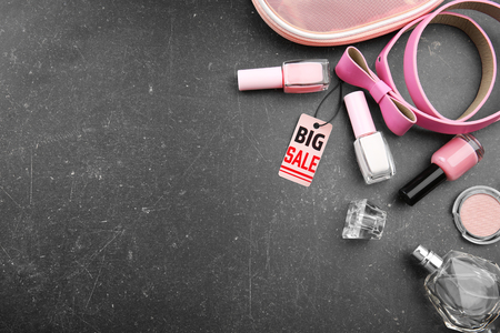 Sale concept. Bright tag with female stuff and cosmetics  on grey backgroundの写真素材