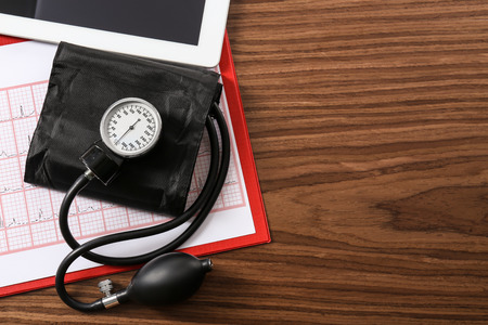 Medical concept. Medical manometer, cardiogram chart on wooden backgroundの写真素材