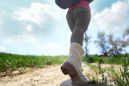Female hiker going up the hill at sunny dayの写真素材