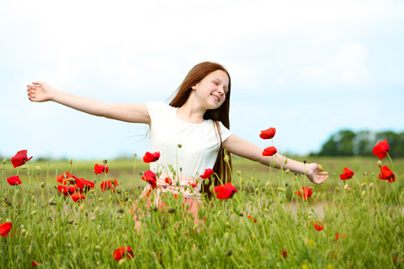 Beautiful girl in poppy fieldの写真素材
