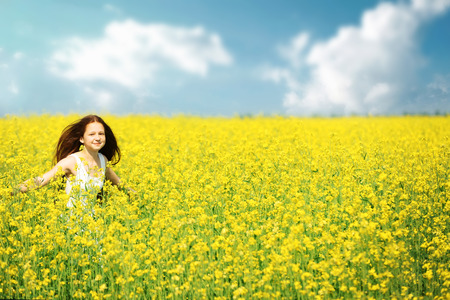 Sweet girl in meadow with wild spring flowersの写真素材