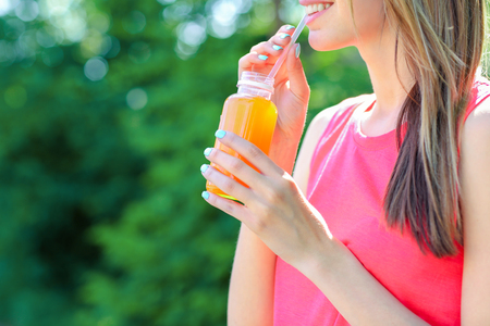 Sportswoman drinking detox juice on streetの写真素材