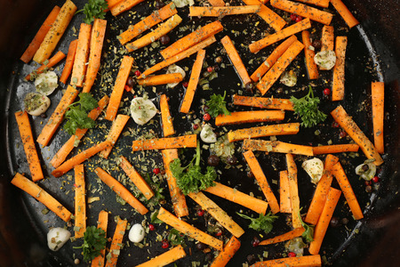 Healthy food and ingredients with sliced carrots, parsley and spices in a pan