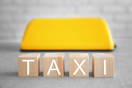 Cubes with word taxi and roof sign on brick wall backgroundの写真素材