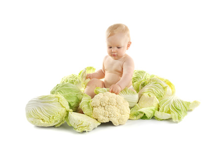 Beautiful baby sitting in green cabbageの写真素材