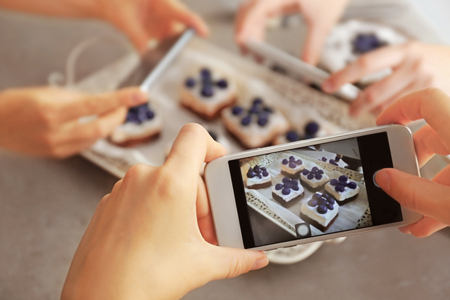 People taking photo of tasty cakes with blueberriesの写真素材