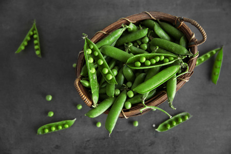 Fresh peas in basket on grey backgroundの写真素材