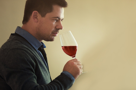 Handsome man tasting red wineの写真素材