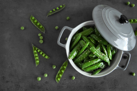 Fresh green peas in saucepan on grey backgroundの写真素材
