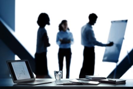 Workplace with laptop and documents on conference background
