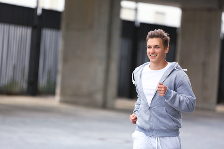 Young man running on the streetの写真素材