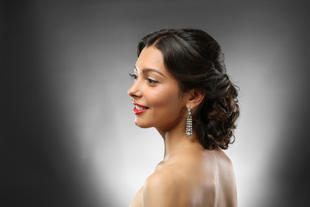 Young beautiful woman with nice hairdo on dark background
