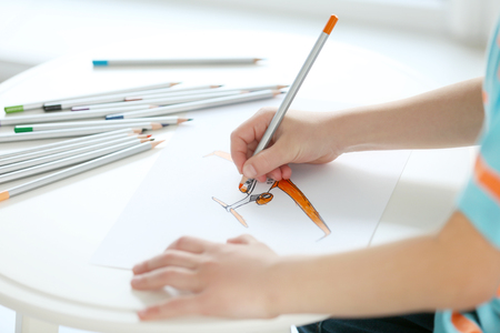 Child's hands drawing picture on paperの写真素材