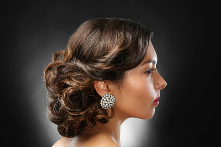 Young beautiful woman with nice hairdo on dark background