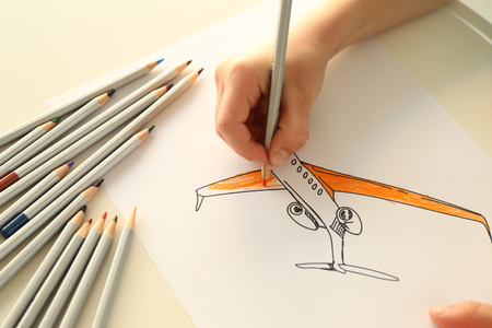Child's hand drawing picture on paper