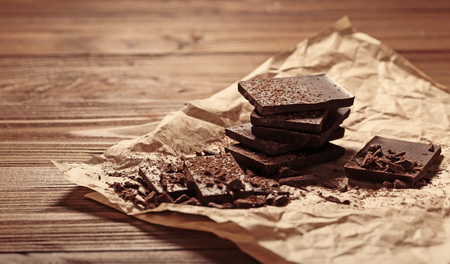 Chocolate pieces covered with cocoa powder on paperの写真素材